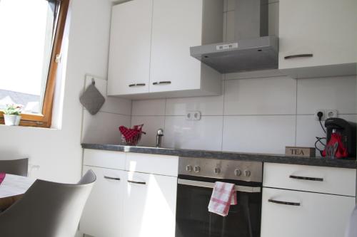 a kitchen with white cabinets and a stove top oven at Haase Eck in Bad Hönningen