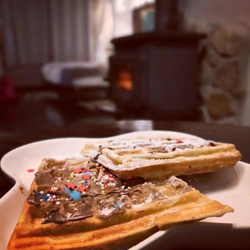a white plate with two pieces of toast with sprinkles at Vanilla Grey in Had Nes