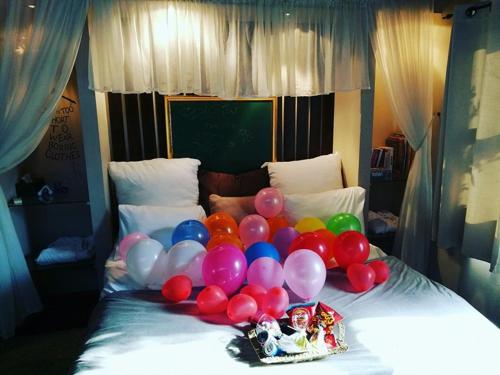 a bunch of balloons on top of a bed at Vanilla Grey in Had Nes