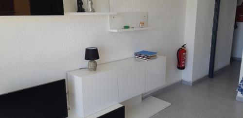 a white table with a lamp and books on it at Apartment Travesia de Santomera in Torrevieja