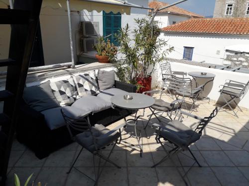 a patio with a table and chairs on a balcony at Filenia in Hydra
