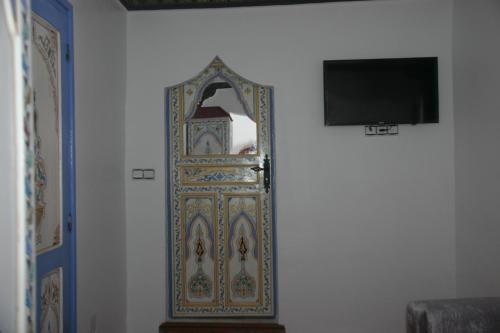 a door with a mirror on a wall at Casa El Haouta in Chefchaouene