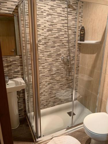 a bathroom with a shower with a toilet and a sink at Hostal Tres Hermanos in Getafe