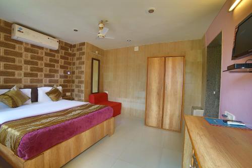 a bedroom with a bed and a television in it at Forest Eco Lodge in Mount Ābu