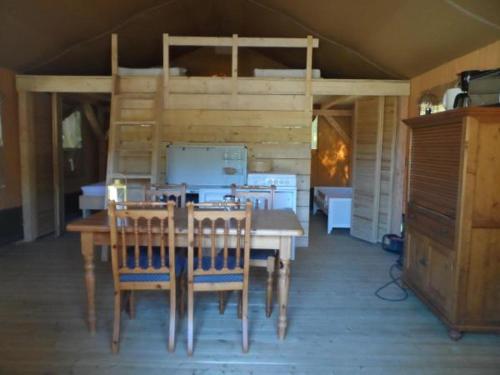 a dining room with a table and a bunk bed at Hoeveheikant Tenten in Lage Mierde