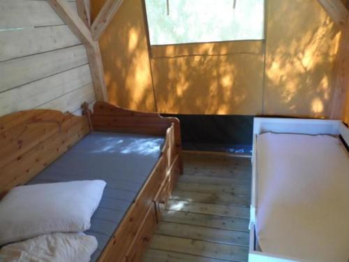 a small room with two beds and a window at Hoeveheikant Tenten in Lage Mierde