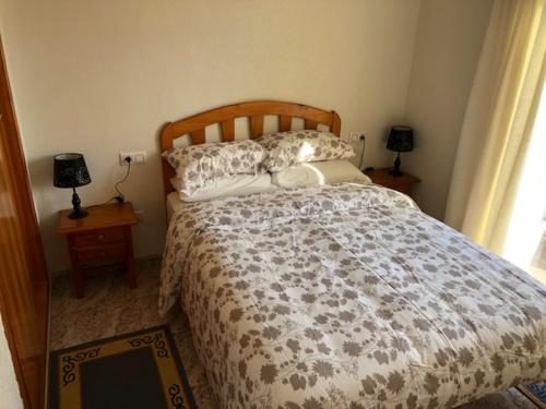 een slaapkamer met een bed, 2 lampen en een raam bij Macerana 1, Torreta III, Torrevieja in Torrevieja