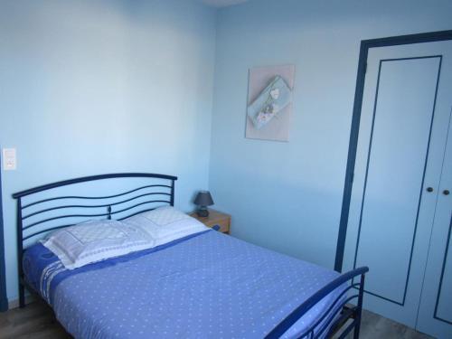 - une chambre bleue avec un lit et un mur bleu dans l'établissement La Hugotière, à Friville-Escarbotin