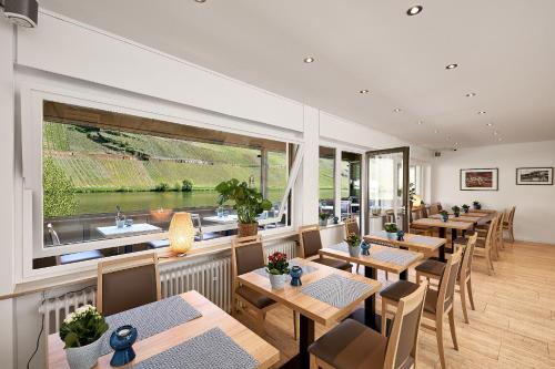 a restaurant with tables and chairs and a large window at Sonnenuhr in Bernkastel-Kues