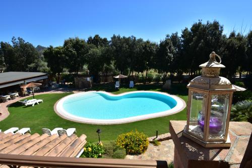 a swimming pool in a yard with a lantern at Hotel Su Giganti in Villasimius