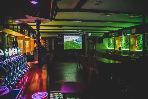 een bar met een televisie en een tafel met stoelen bij Tatler Jack in Killarney
