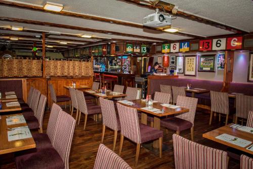een restaurant met houten tafels en stoelen en een bar bij Tatler Jack in Killarney