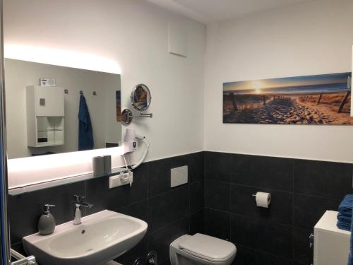 a bathroom with a white sink and a toilet at Prerow „Seaside“-strandnah! in Prerow