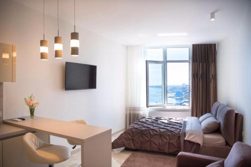 a living room with a bed and a desk in a room at Sea Star Apartments (sea view) in Odesa