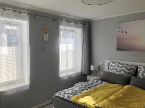 a bedroom with a bed and two windows at Prerow „Seaside“-strandnah! in Prerow