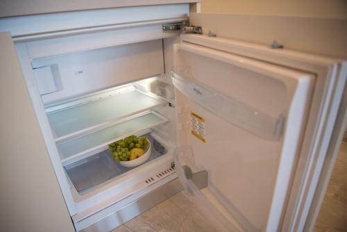 an open refrigerator with a bowl of apples in it at Sea Star Apartments (sea view) in Odesa
