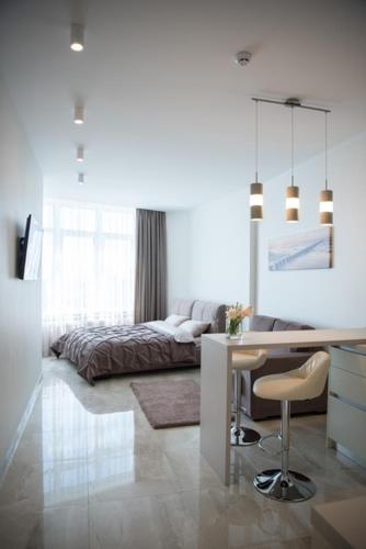 a living room with a desk and a bed at Sea Star Apartments (sea view) in Odesa