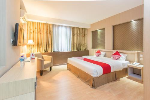 Cette chambre comprend un lit et un bureau. dans l'établissement OYO 663 Hotel Sejati, à Balikpapan
