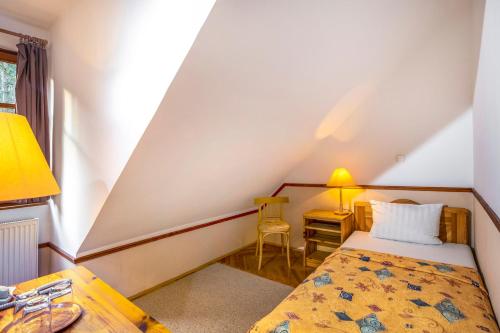 a small bedroom with a bed and a desk at Bakony Hotel in Bakonybél