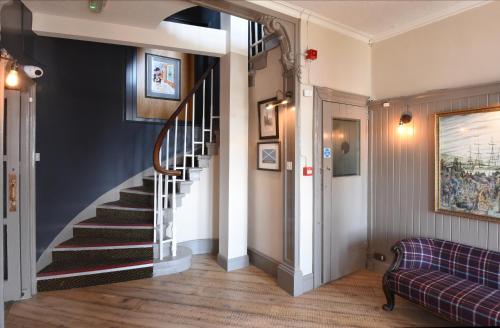 a hallway with a spiral staircase in a home at Ardencaple Hotel by Greene King Inns in Rhu