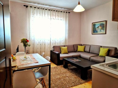 a living room with a couch and a table at All Seasons Apartments in Shkodër