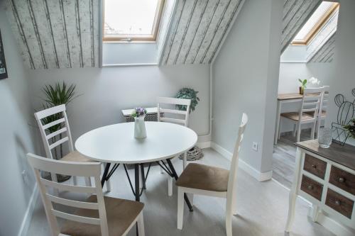 ein Esszimmer mit einem weißen Tisch und Stühlen in der Unterkunft Farmhouse Apartman in Eger