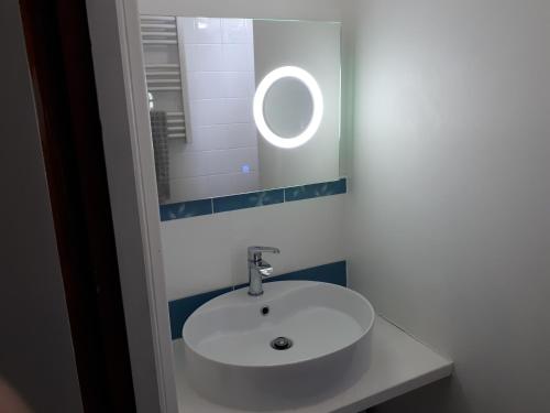 サン・ジュリアン・アン・ボルヌにあるLes Sables Blancsのバスルーム(白い洗面台、鏡付)