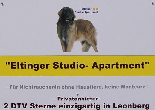 un perro parado sobre un cartel en Eltinger Studio Apartment, en Leonberg