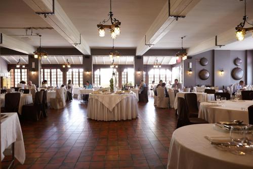 卡斯蒂奧內德拉普雷索拉納的住宿－Active Hotel，宴会厅配有白色桌子,人们坐在宴会厅里