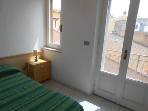 a bedroom with a bed and an open window at PENSIONE VERDE LUNA in Orbetello
