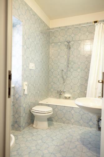 a bathroom with a toilet and a tub and a sink at Lo Chalet in Castione della Presolana