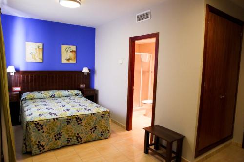 a bedroom with a bed and a door to a bathroom at Hotel Rocio in Villafranca de Córdoba