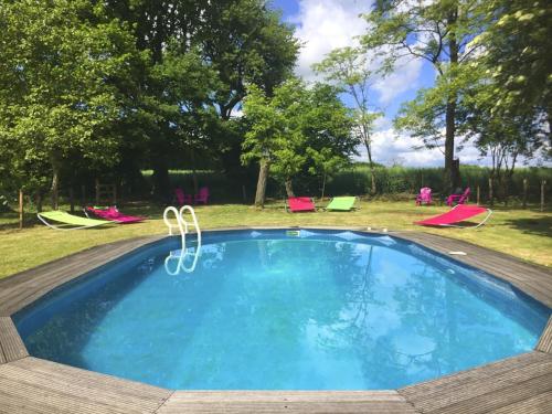una piscina en un patio con sillas y árboles en La Grosse Talle, en Sepvret