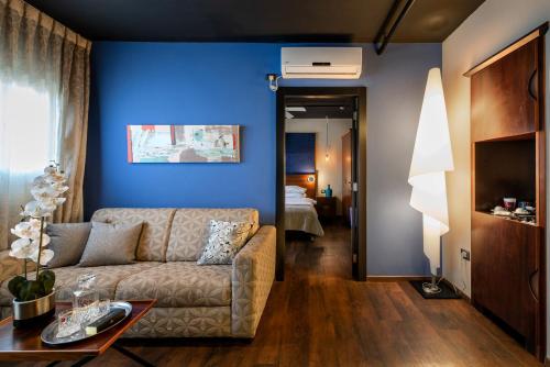 a living room with a couch and a blue wall at PLAY Seaport Suite Hotel TLV in Tel Aviv