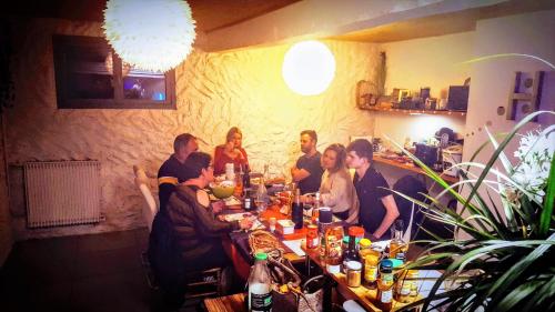 a group of people sitting around a long table at Skymist Maison d'hôtes in Biert