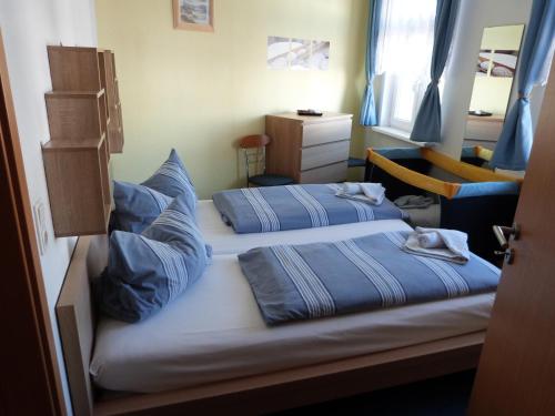 1 Schlafzimmer mit 2 Betten und blauen Kissen in der Unterkunft Haus zum Stern in Ahlbeck