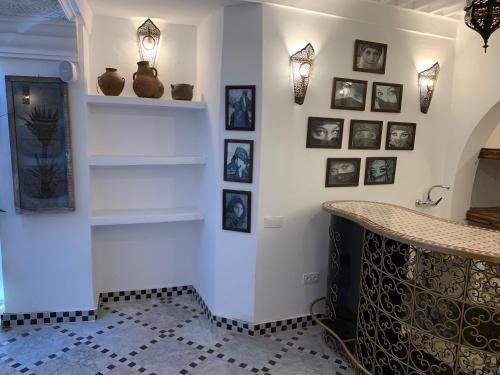 a room with a counter and pictures on the wall at Riad Abaka hotel & boutique in Marrakech