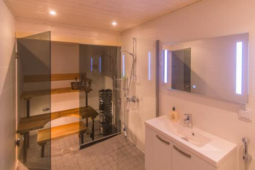 uma casa de banho com um chuveiro, um lavatório e um espelho. em Jääskän Loma Kojolapark asunto 3, Alahärmä Kauhava em Voltti