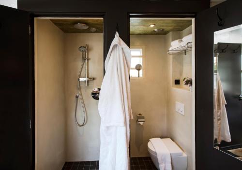 a bathroom with a shower with a white robe at SWEETS - Amstelschutsluis in Amsterdam