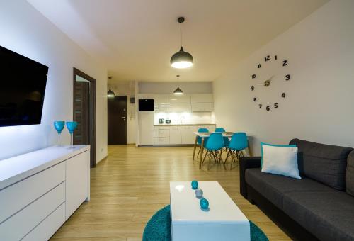 a living room with a couch and a table at Apartament Aquamarine Polanki in Kołobrzeg