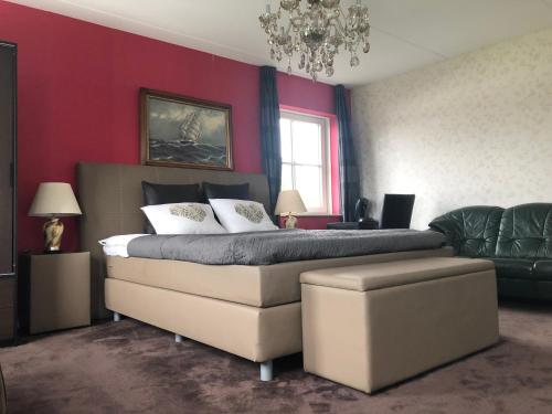um quarto com uma cama grande e um sofá em B&B nancy in holland em Aalten