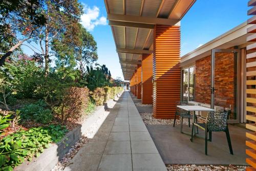 a walkway with a table and chairs next to a building at Comfort Inn & Suites Warragul in Warragul