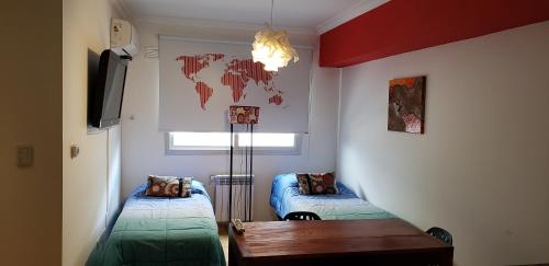 a room with two beds and a table in it at Apartamento Reyes Catolicos in Salta