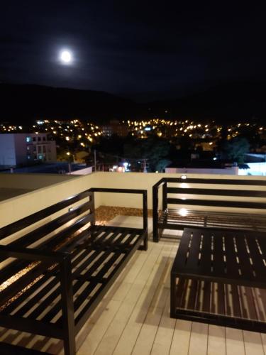 two benches sitting on top of a roof at night at Apartamento Reyes Catolicos in Salta