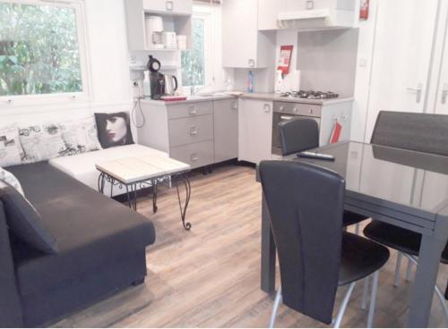 een keuken en een woonkamer met een bank en een tafel bij Mobile Home Service Hotelier in Fréjus