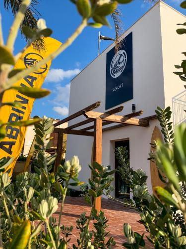 a sign on the side of a building with plants at ProKite Alby Rondina - RESORT - in Birgi Vecchi