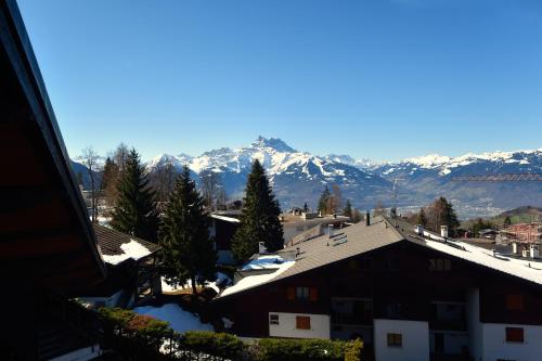 a view of snow covered mountains from a city at Villars soleil in Villars-sur-Ollon
