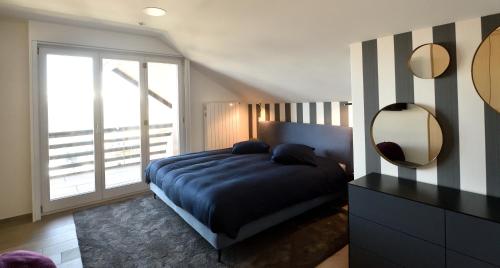 a bedroom with a bed and a mirror and a window at Villars soleil in Villars-sur-Ollon