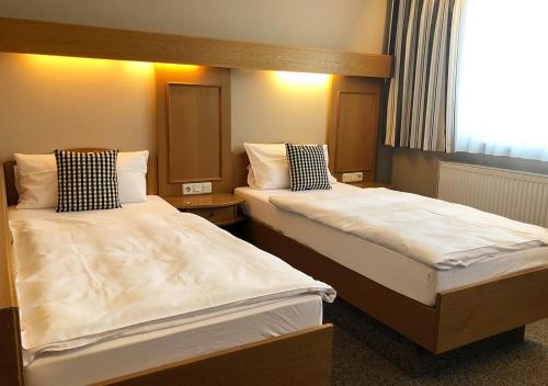 um quarto de hotel com duas camas e uma janela em Mangolds Boutique Hotel & Fruehstuecksmeisterei em Schweinfurt