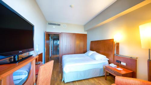 a hotel room with a bed and a flat screen tv at Bull Reina Isabel & SPA in Las Palmas de Gran Canaria